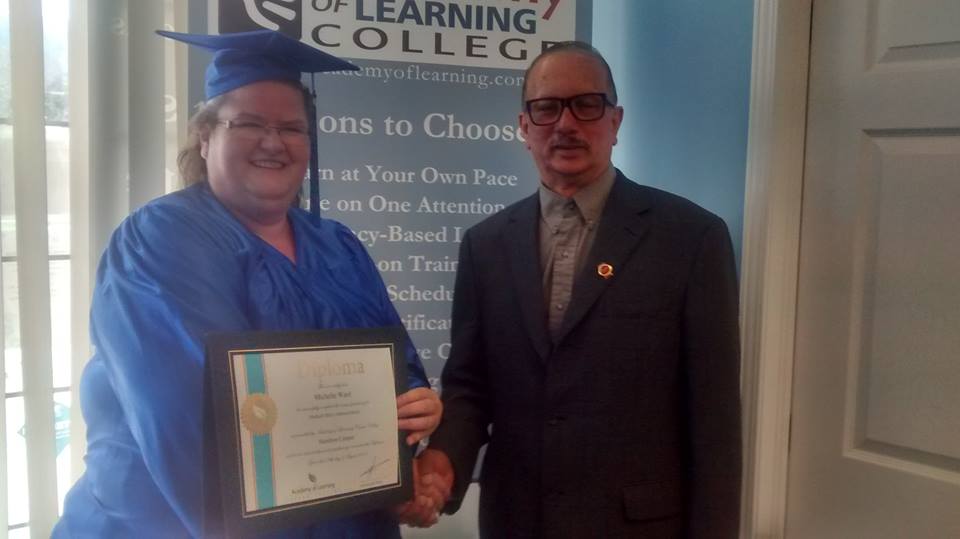 Graduate in cap and gown receiving diploma certificate at Academy of Learning College