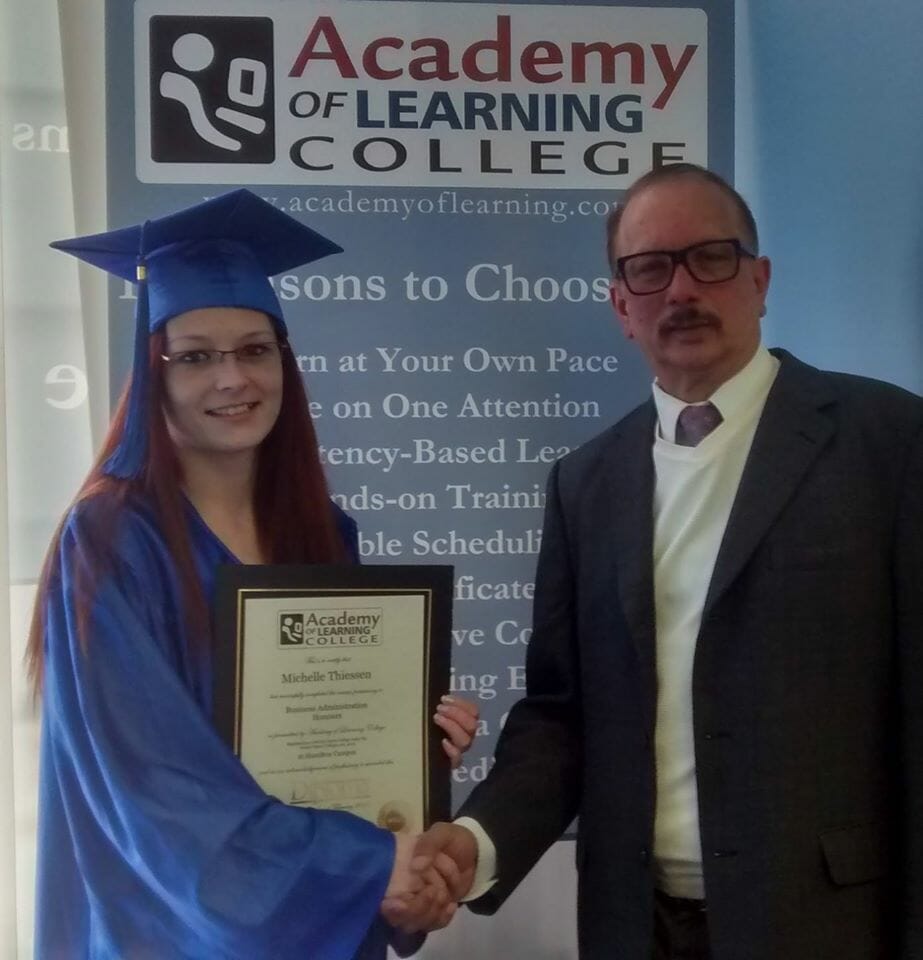 Graduate receiving certificate from college director during graduation ceremony