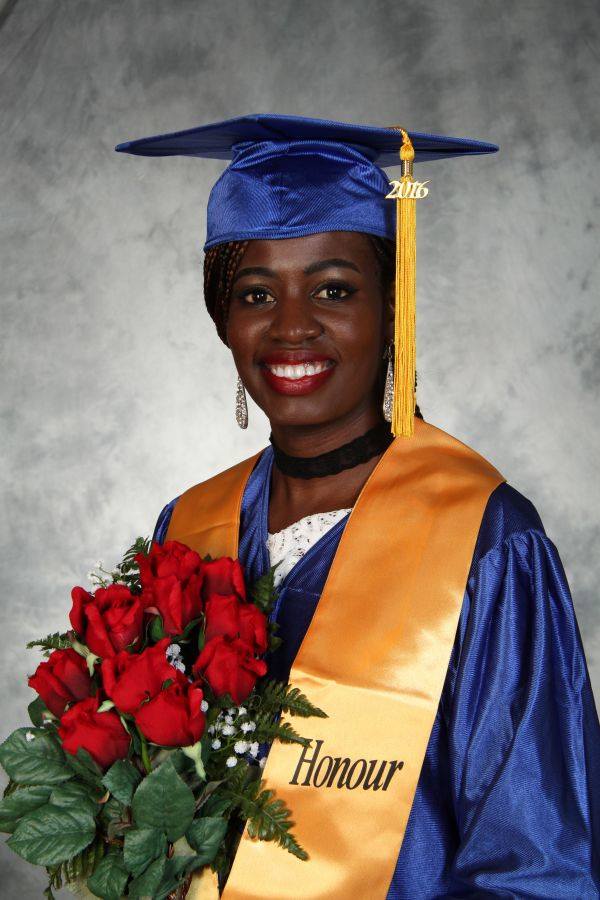 2016 Graduation Photo 33 – Toronto – Bay/Bloor Campus Female graduate wearing blue cap and gown with honour stole holding red roses during graduation portrait