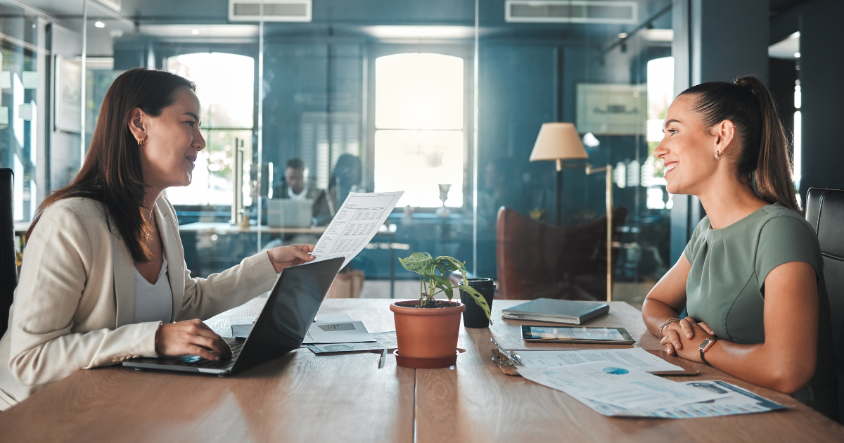 Professional job interview in Canadian office with interviewer reviewing candidate resume