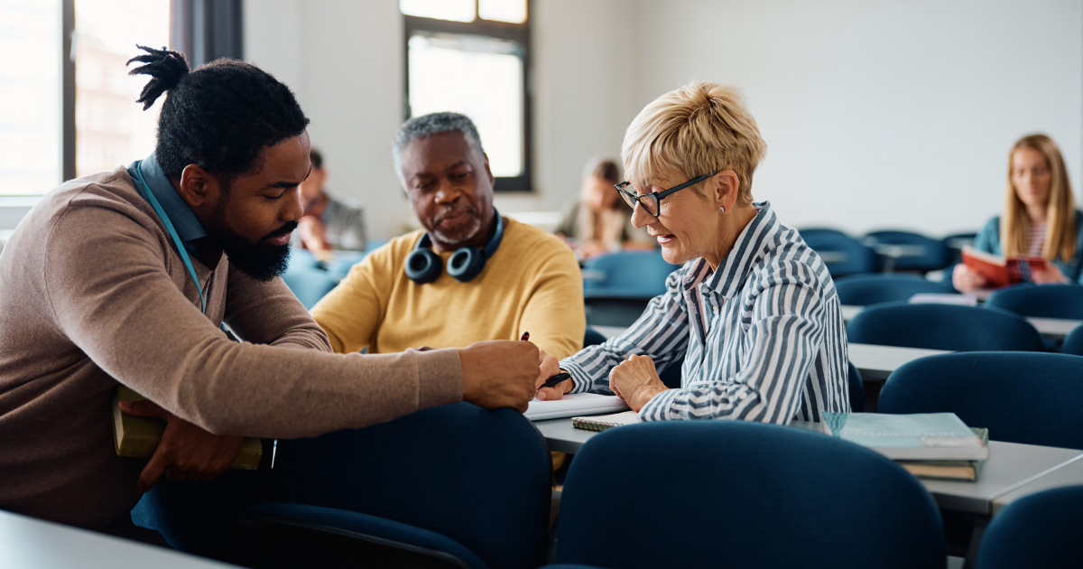 Adult learners in career training program discuss course materials at Canadian career college