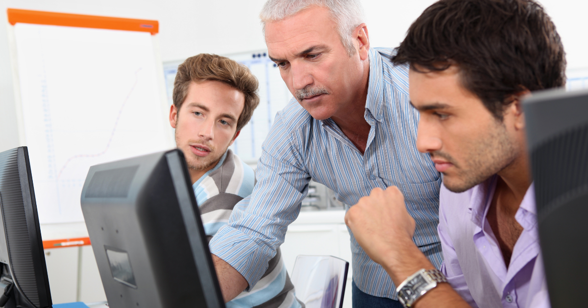 Career change students learning computer skills with instructor at training college
