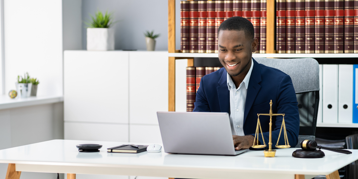 desk for a paralegal or law clerk Law clerk at modern legal office desk reviewing documents on laptop with law library books and scales of justice, representing entry-level legal careers in Canada