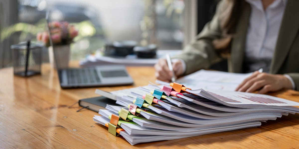 Law clerk reviewing organized legal files with colored tabs showing document management skills required for legal office positions
