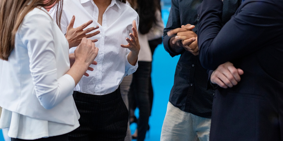 Professionals networking at a career event, showcasing the importance of building connections while unemployed.