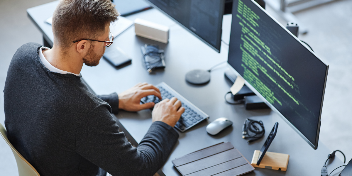 A web developer coding on a laptop, applying front-end and back-end skills acquired from a one-year certificate program.