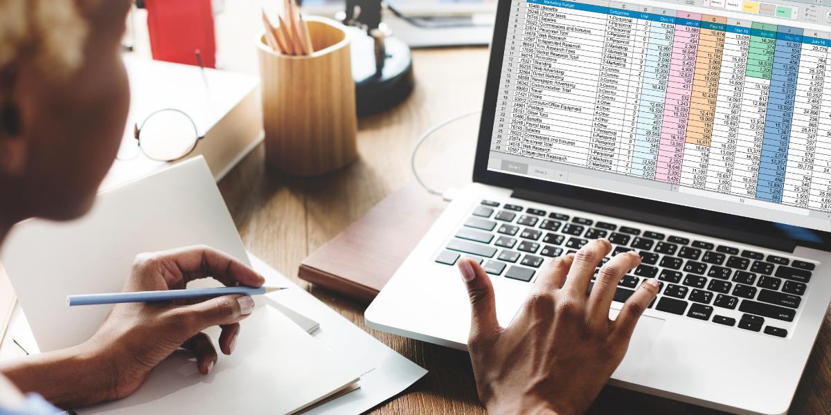 Person reviewing detailed financial spreadsheet in Microsoft Excel showing color-coded data analysis for business accounting, demonstrating Excel's powerful data management capabilities.
