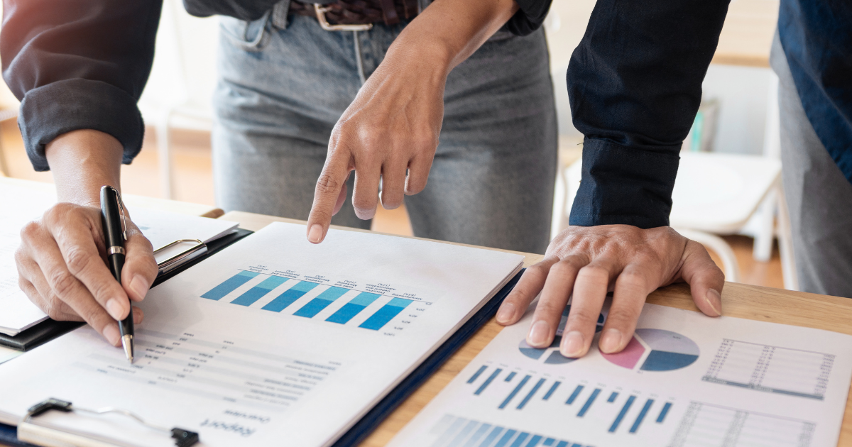 Financial analysts reviewing charts and reports during collaborative business meeting in Canada