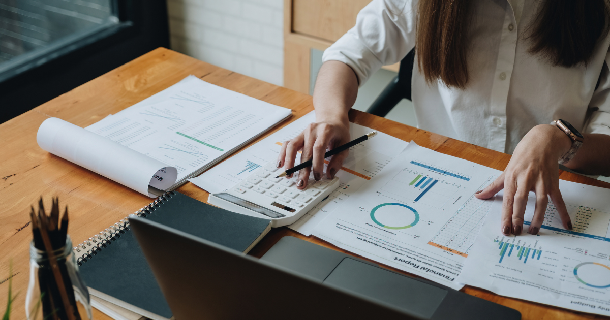 Professional accountant using calculator to review financial statements and budget reports